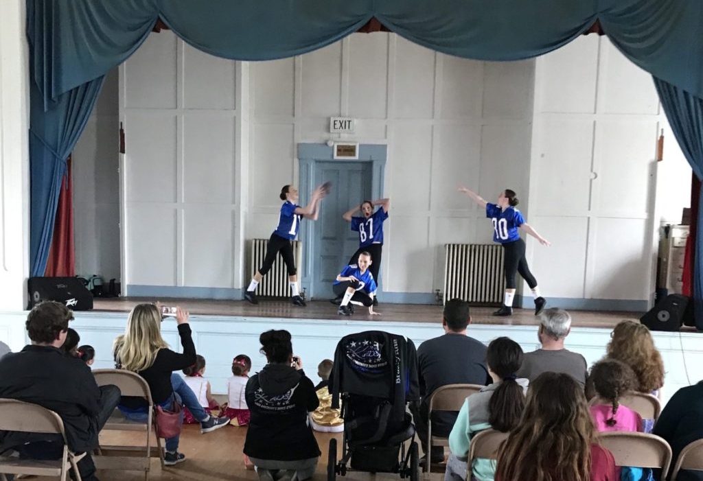 An audience watches young dancers perform on the Great Hall stage at the North Brookfield Town House during MayFest, 2019. The Architectural Heritage Foundation (AHF) is helping the Friends of the North Brookfield Town House to preserve and redevelop the historic building.
